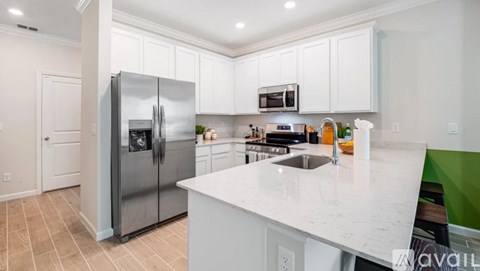 A kitchen with white cabinets and a marble countertop.