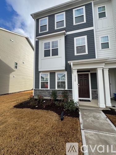 A two-story house with a front yard and a driveway.