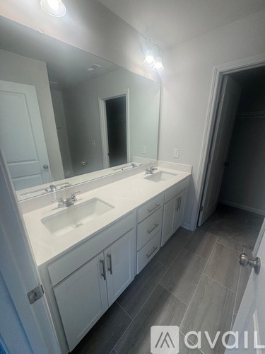 A bathroom with a sink, mirror, and cabinets.