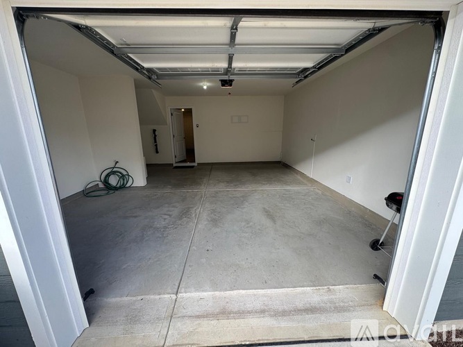 A spacious garage with a concrete floor and white walls.