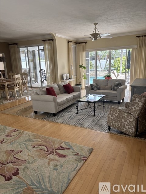 A living room with a grey couch and a rug with a floral pattern.