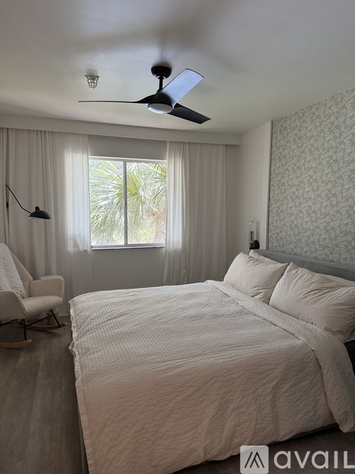 A bedroom with a large bed and a ceiling fan.