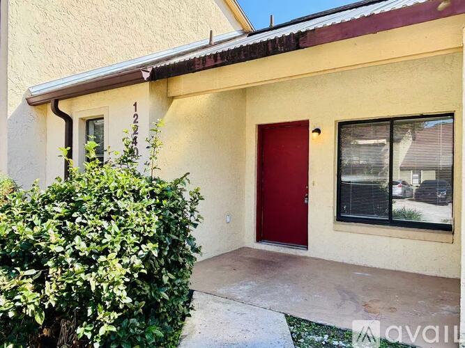 A house with a red door and a window with blinds.
