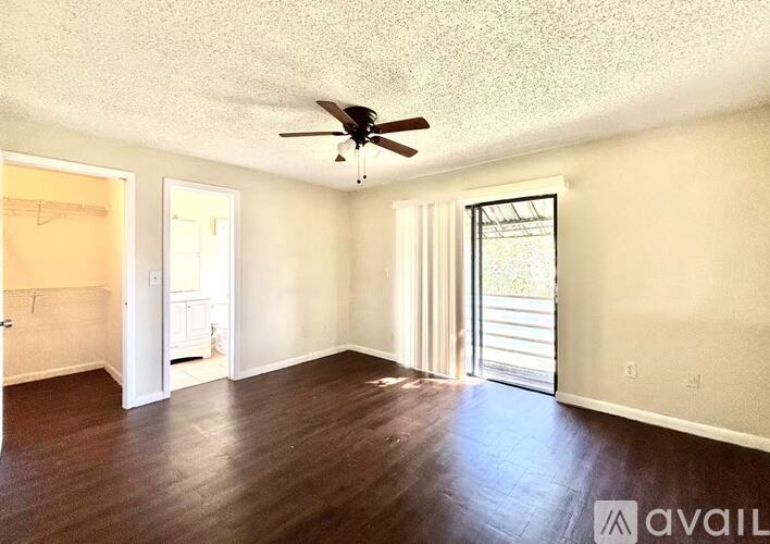 A spacious room with a ceiling fan and sliding glass doors.