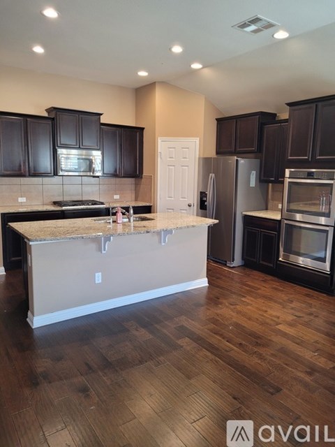 A kitchen with dark brown cabinets and a white door.