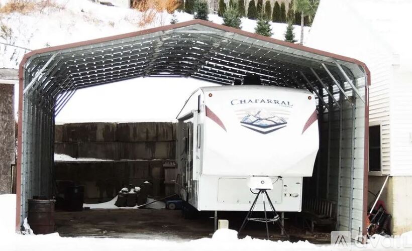 A white boat is parked in a garage.
