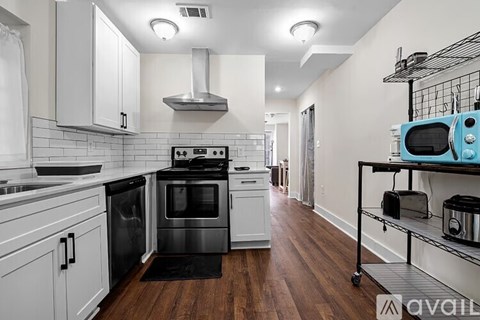 A kitchen with white cabinets and a black stove top oven.