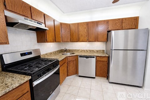 A kitchen with wooden cabinets and a granite countertop.