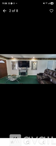A living room with a couch and a television.