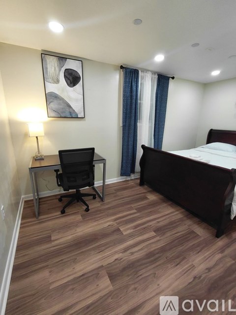 A bedroom with a bed, desk, and chair.
