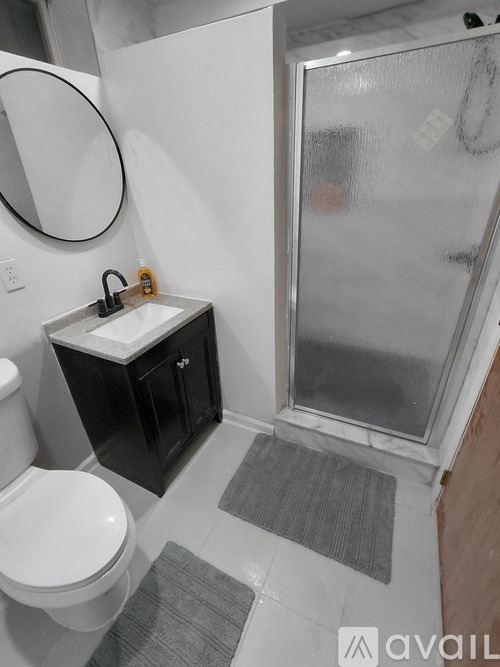 A bathroom with a toilet, sink, and shower.