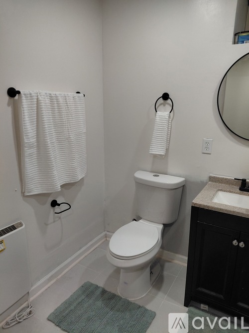A bathroom with a toilet, sink, and towel rack.