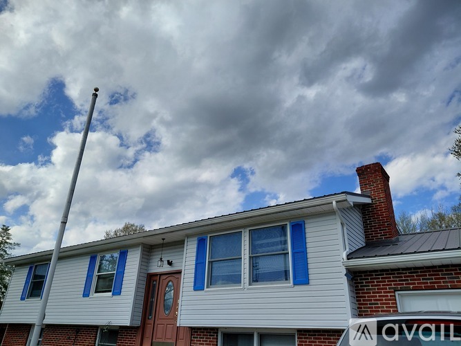 A house with a red door and a sign that says "AVAIL" on the side.