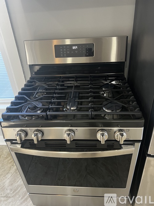 A modern stainless steel gas stove with a digital control panel.