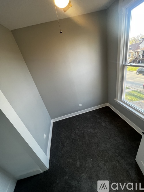 A room with a window and a car parked outside.