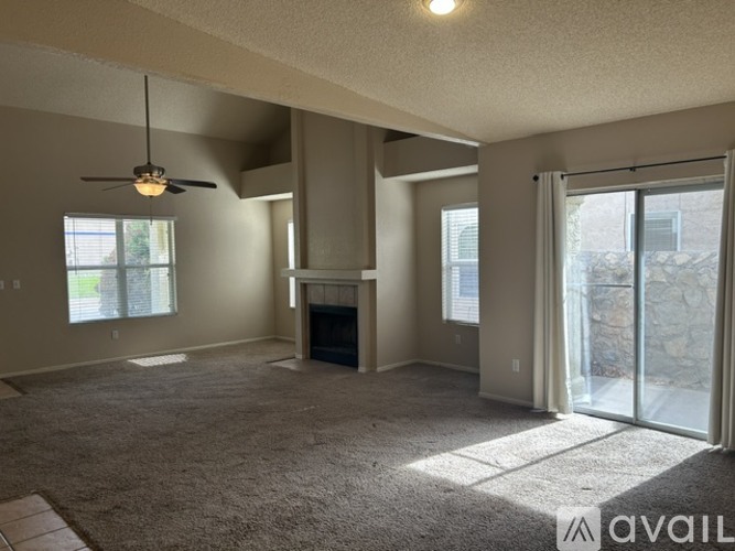 A spacious living room with a fireplace and sliding glass doors.
