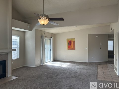 A spacious living room with a fireplace and a painting on the wall.