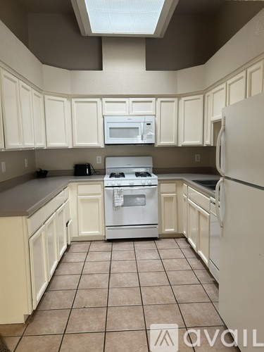 A kitchen with white cabinets and appliances.