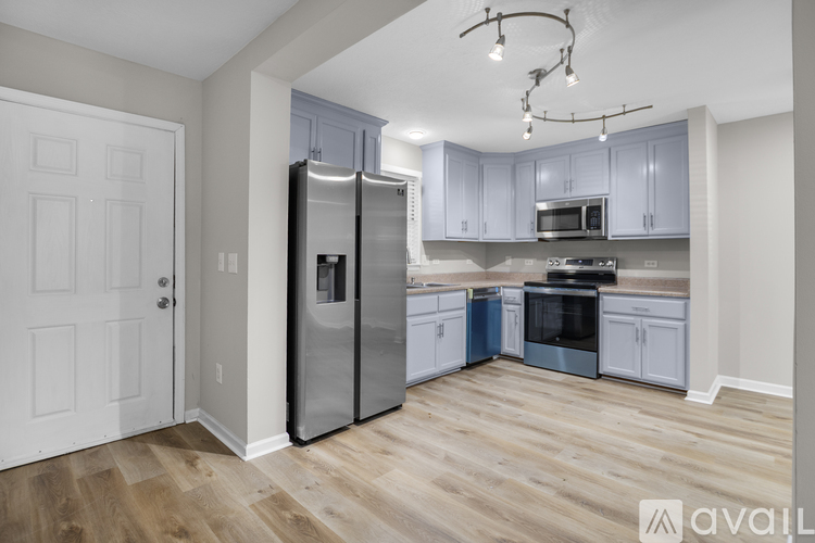 A kitchen with wooden floors and stainless steel appliances.