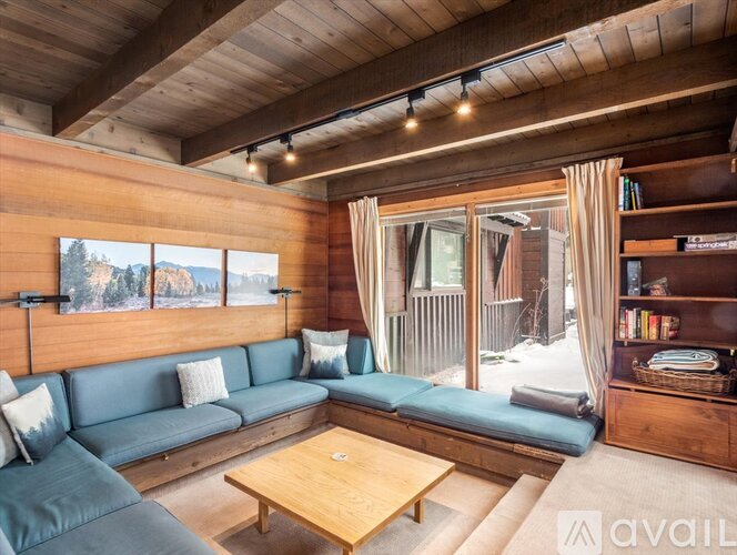 A living room with a blue couch and a wooden coffee table.