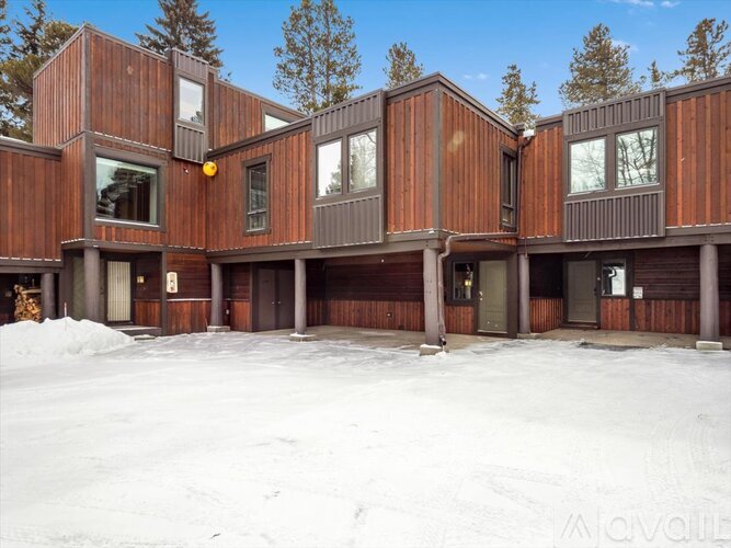 A large wooden building with a snowy ground in front.