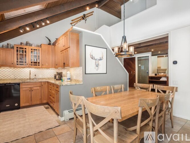A kitchen with wooden chairs and a wooden table.