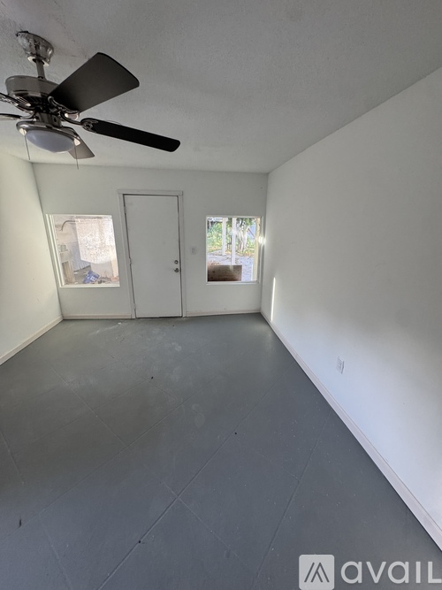 A room with a ceiling fan and two doors.