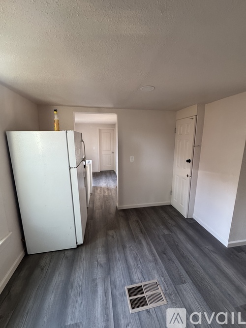 A kitchen with a white fridge and a white door.