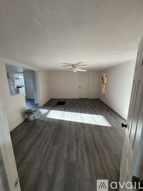A room with wooden flooring and a ceiling fan.