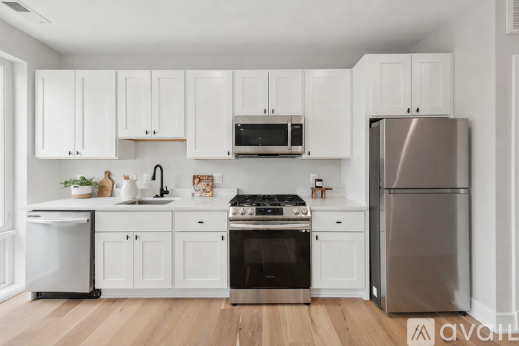 A kitchen with white cabinets and a stainless steel refrigerator.