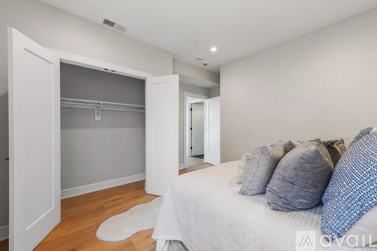A bedroom with a bed, pillows, and a wardrobe.