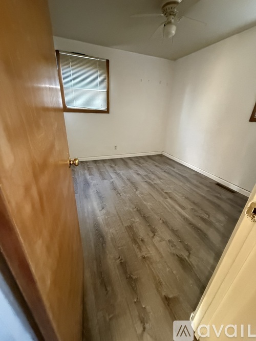A room with wooden flooring and a ceiling fan.