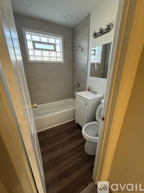 A small bathroom with a toilet, sink, and tub.