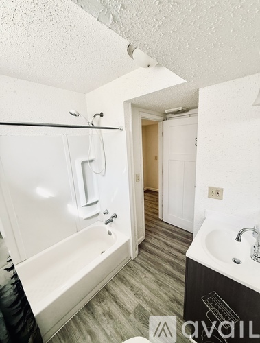 A bathroom with a white tub and sink.