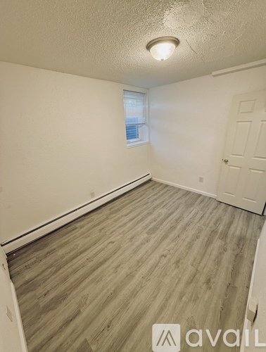 A room with wooden flooring and a window.
