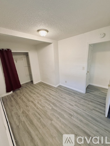A room with a grey floor and a red curtain.