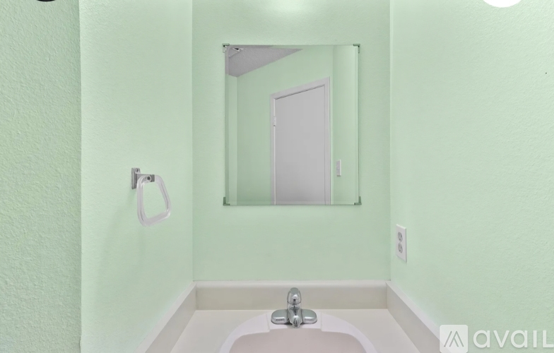 A bathroom with a green wall and a white sink.
