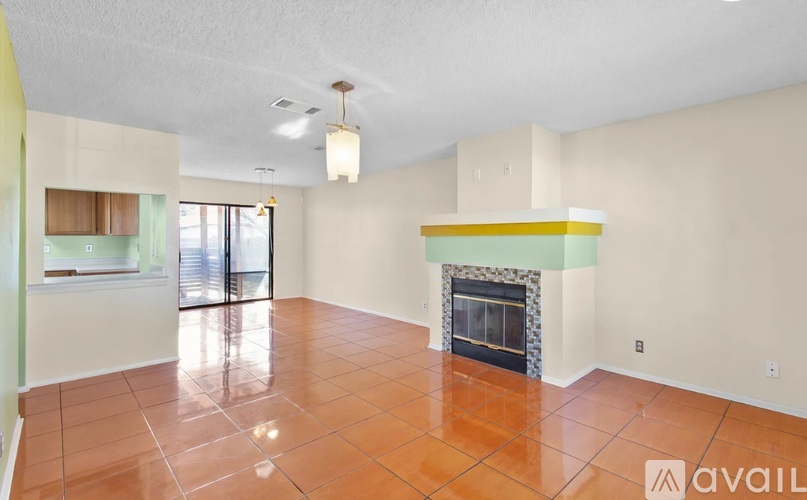 A living room with a fireplace and tile flooring.