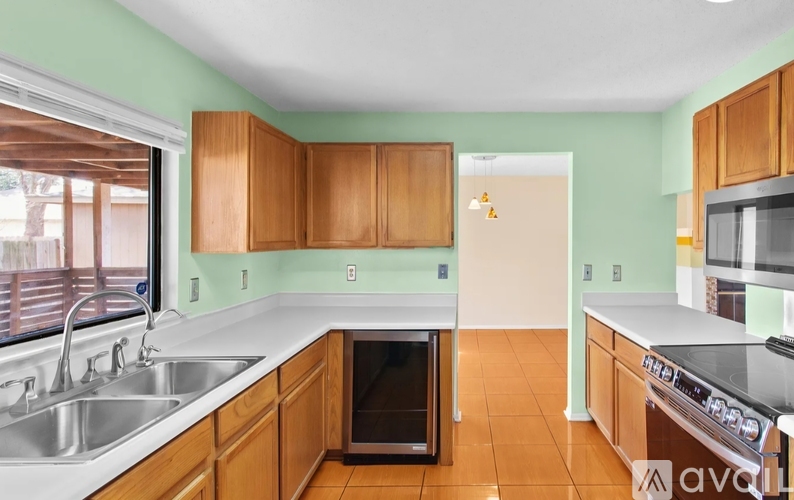 A kitchen with wooden cabinets and a white sink.