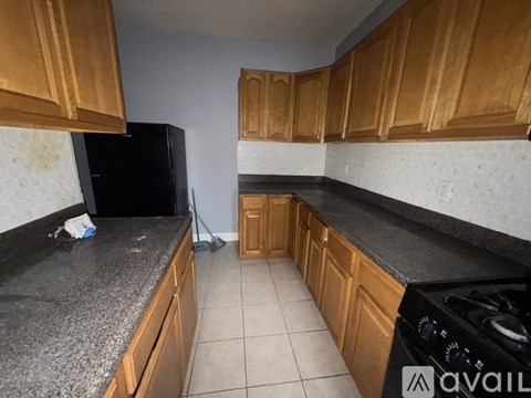 A kitchen with wooden cabinets and black countertops.