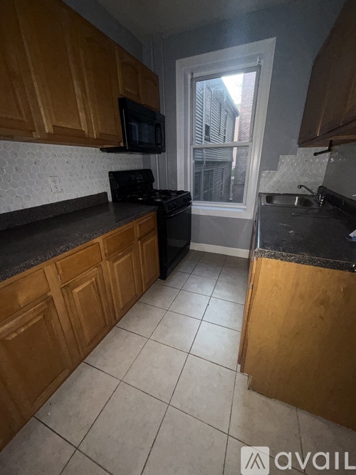 A kitchen with wooden cabinets and black countertops.