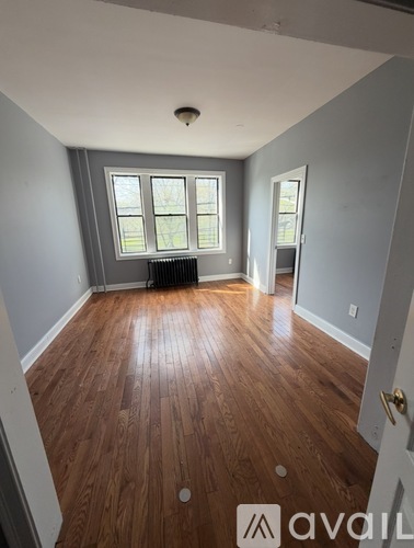 A narrow hallway with a wooden floor and white walls.