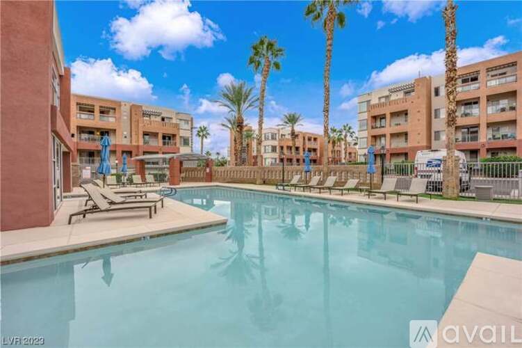 A pool surrounded by palm trees and sun loungers.