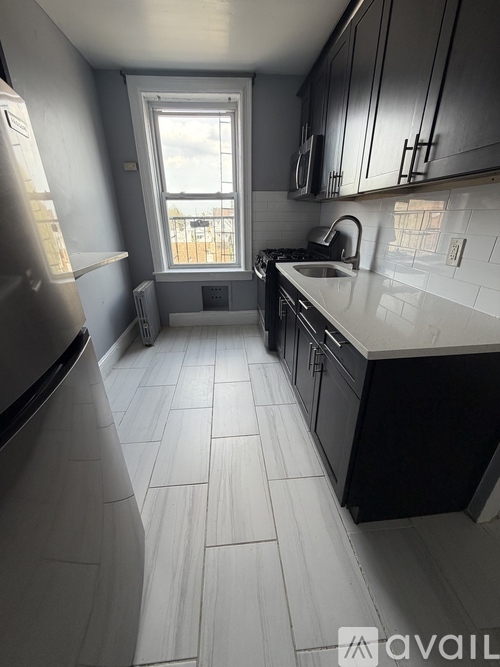 A kitchen with black cabinets and a white countertop.