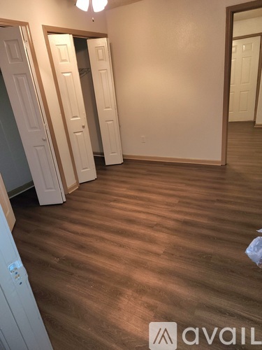 A room with wooden flooring and white doors.