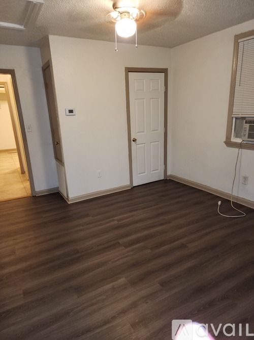 A room with a white door and a window with blinds.