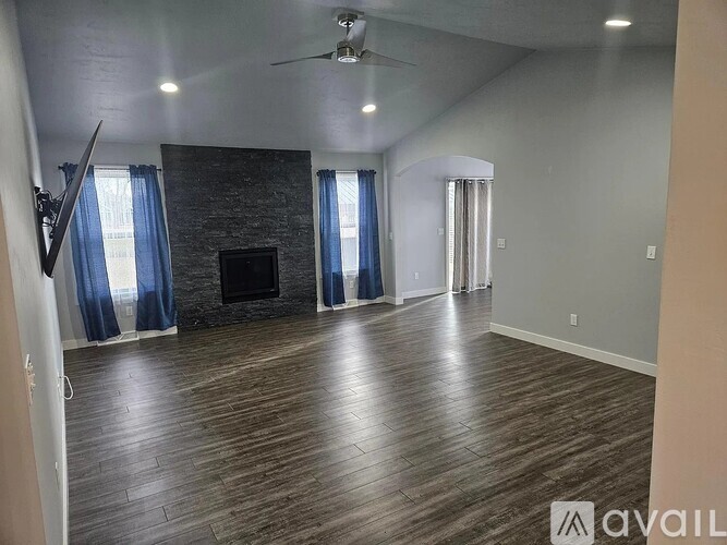 A spacious living room with a fireplace and hardwood floors.