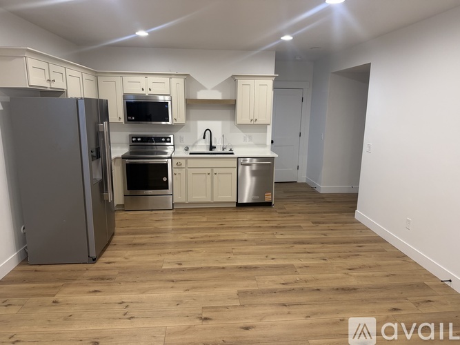 A kitchen with wooden floors and white walls.