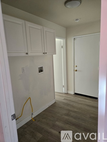 A room with white cabinets and a door.