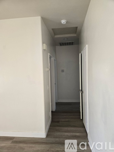 A hallway with a door on the right and a light on the ceiling.